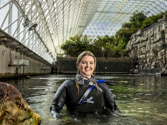 Photo credit: The University of Arizona, Description: Image of a woman in the Biosphere 2 Ocean/Coral Reef Environment, Image taken from: https://biosphere2.org/